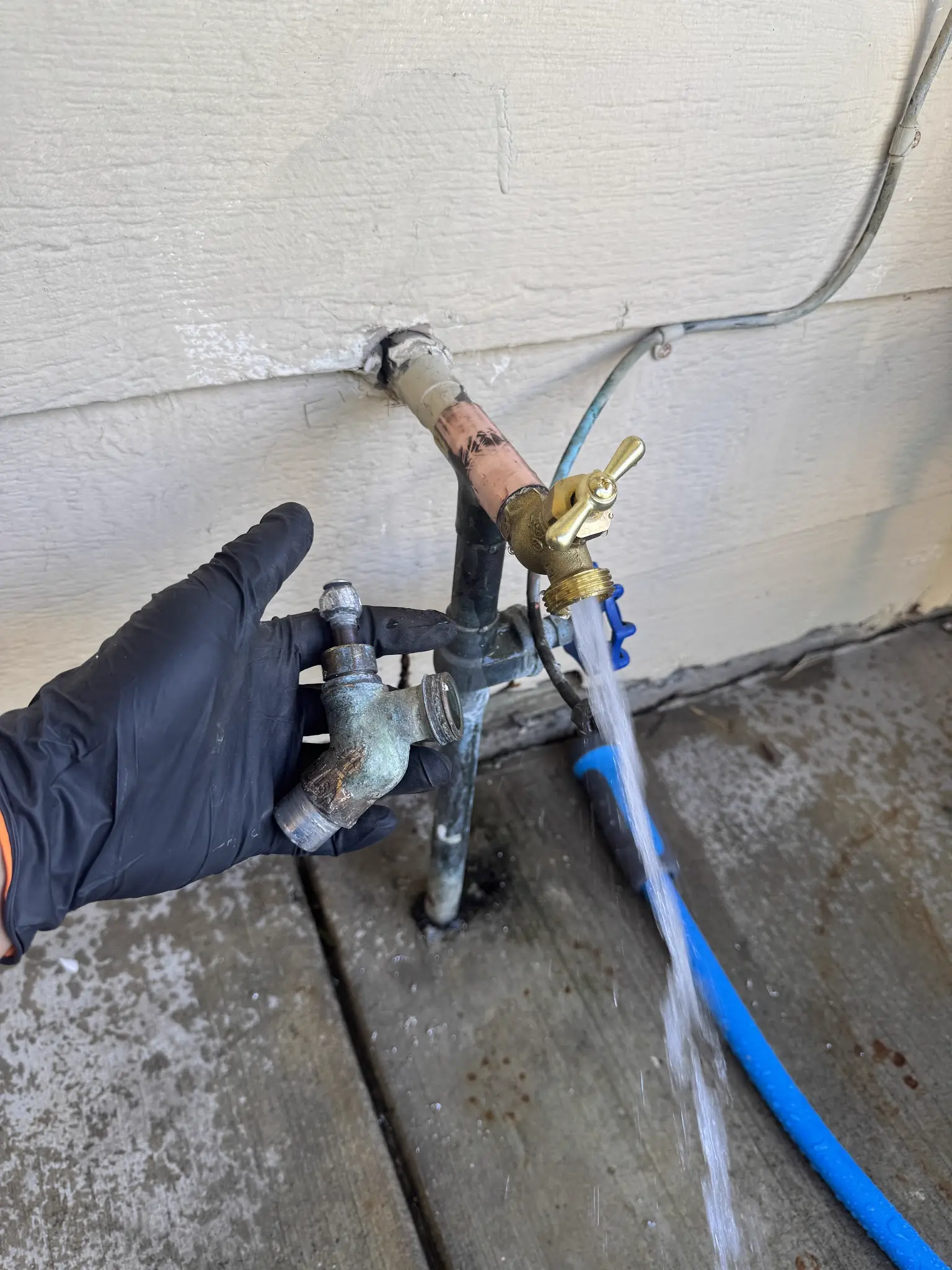 Outdoor hose bib repair with a new brass faucet shown flowing water