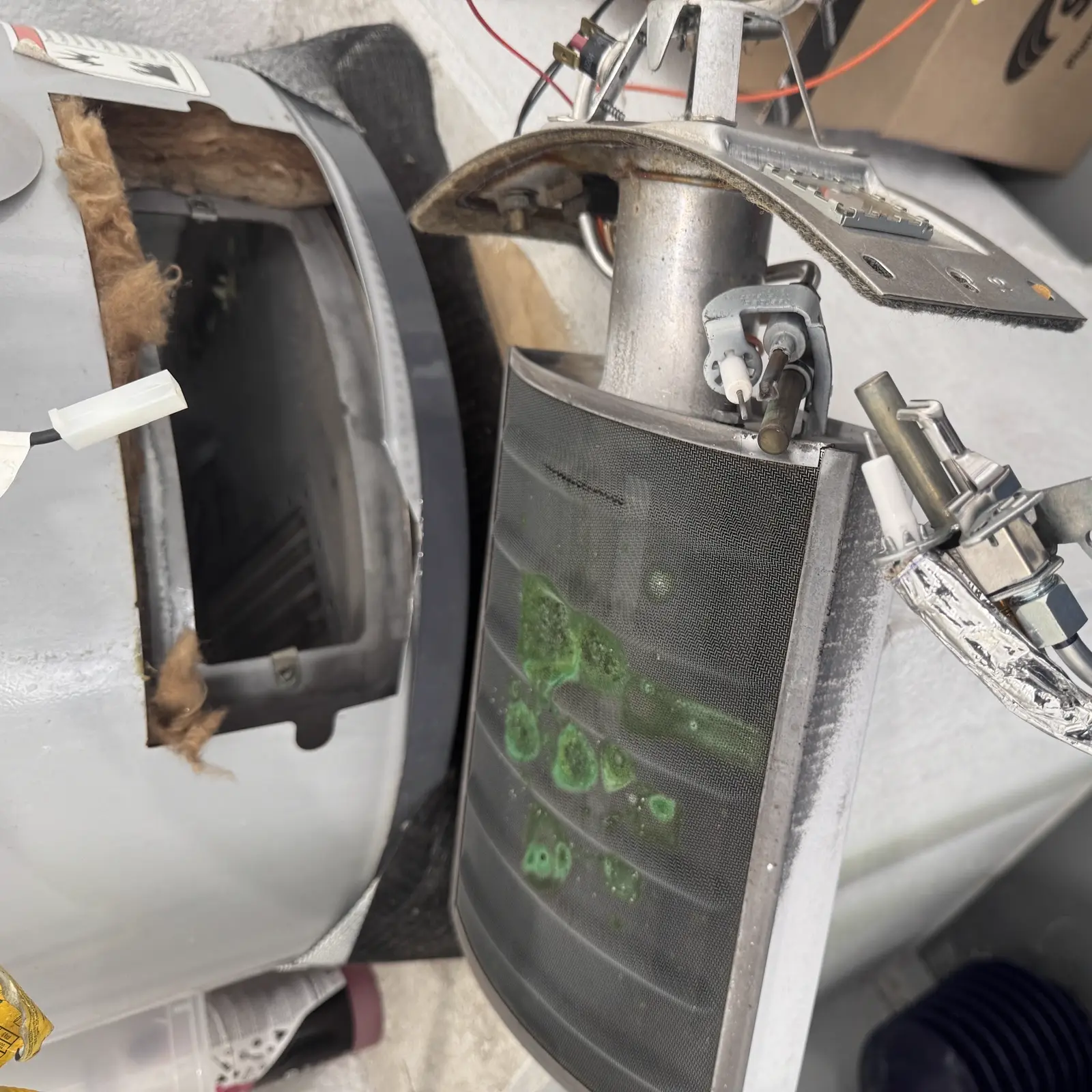 Close-up of a water heater burner assembly during diagnostic service