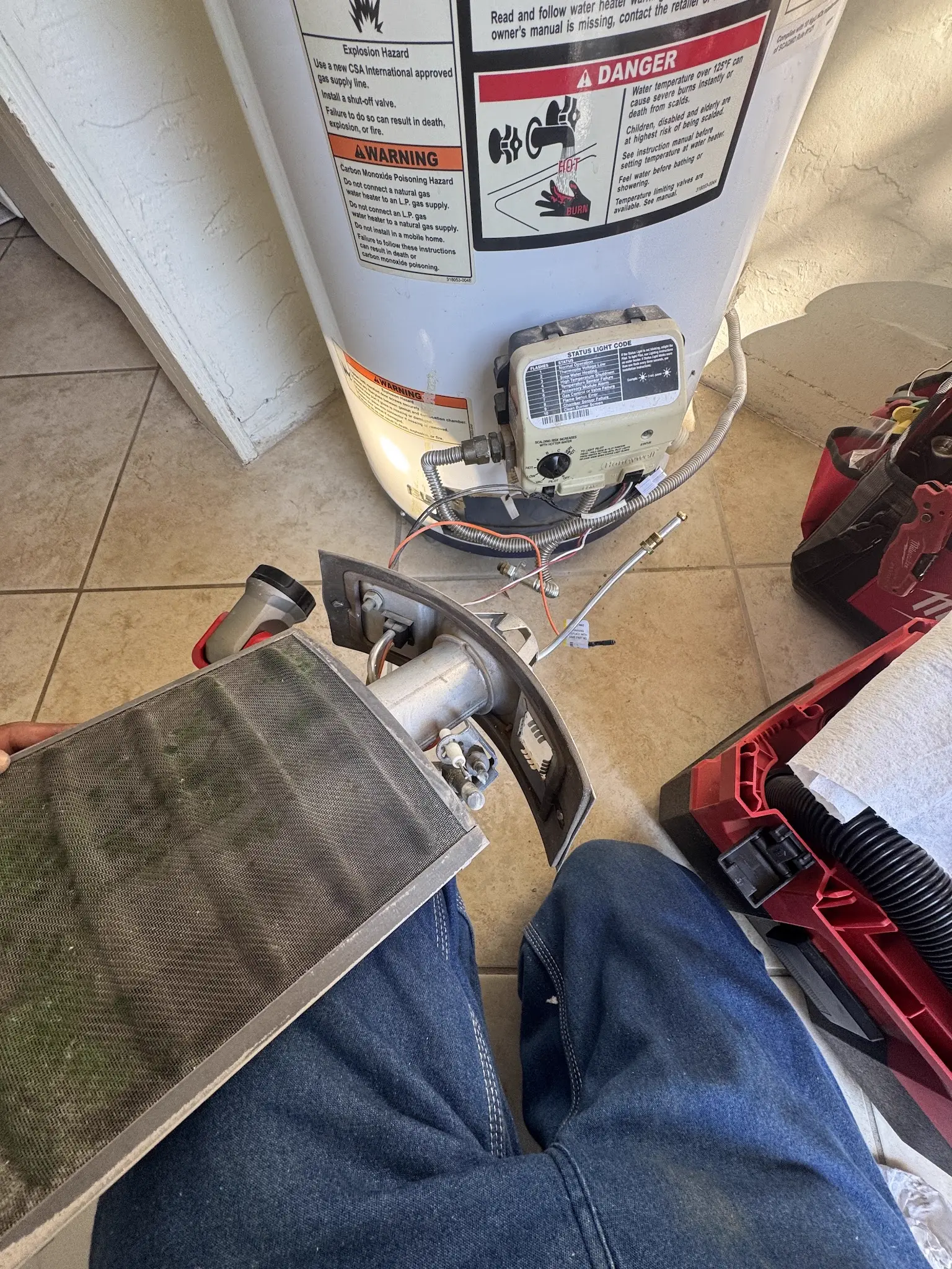 Gas water heater burner service in progress with tools on site